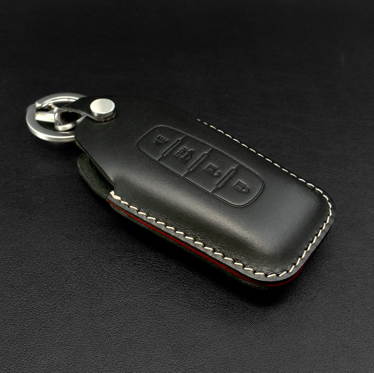 Infiniti key fob inserted into leather case, showing fit