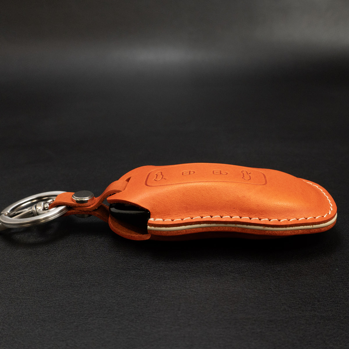 Porsche Macan EV key fob leather cover, close-up of snap closure
