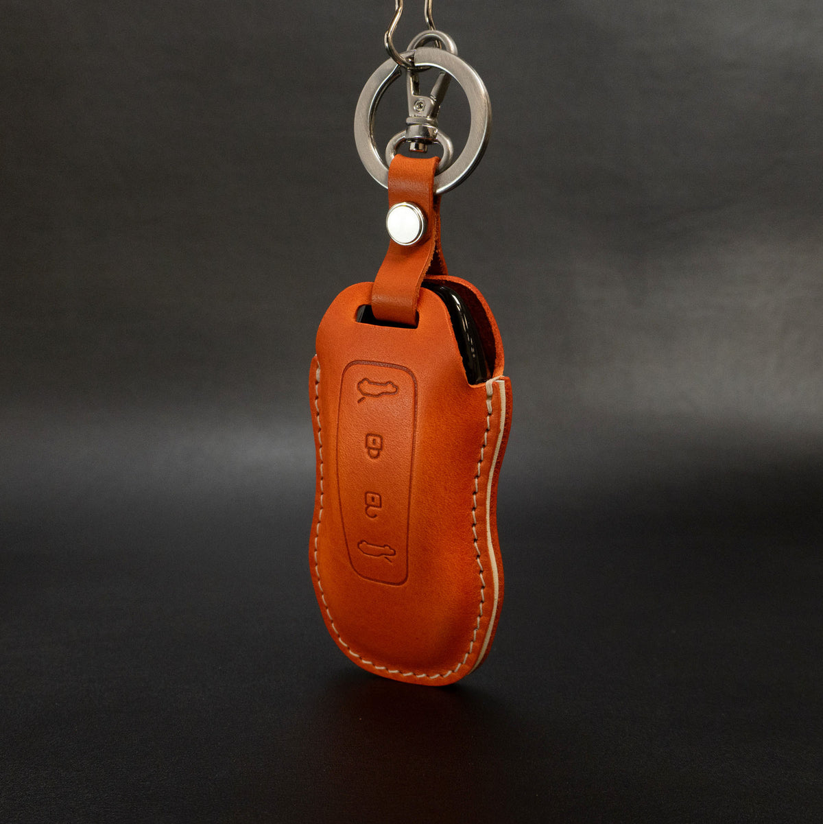 Porsche Macan EV key fob inserted into leather cover, showing fit