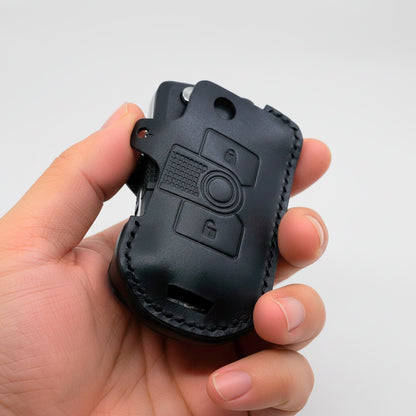 Grenadier Black car key fob cover held in a hand against a white background